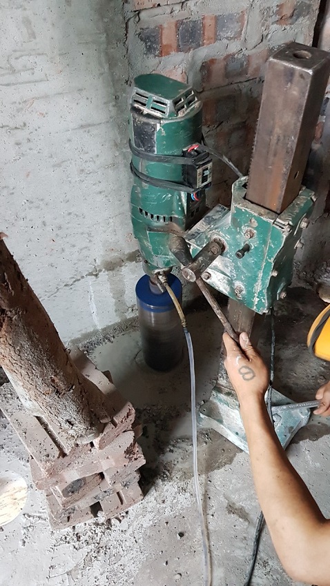 Thợ khoan rút lõi đang khoan lỗ thoát sàn nhà vệ sinh, lỗ thoát xí