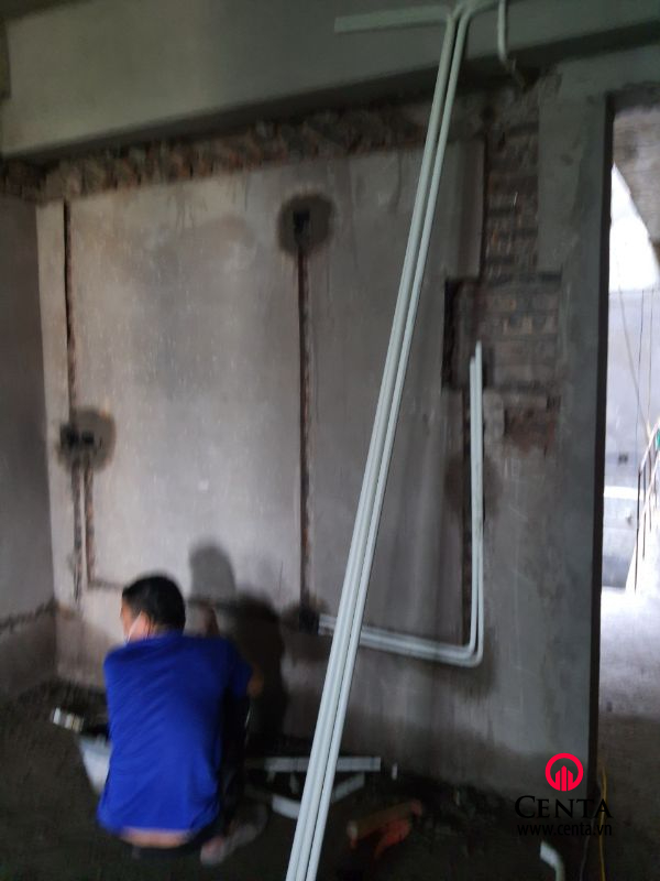 Thợ chôn ống và ghim bằng thép buộc vào âm tường